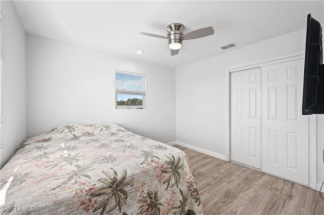 bedroom featuring ceiling fan, light hardwood / wood-style flooring, and a closet