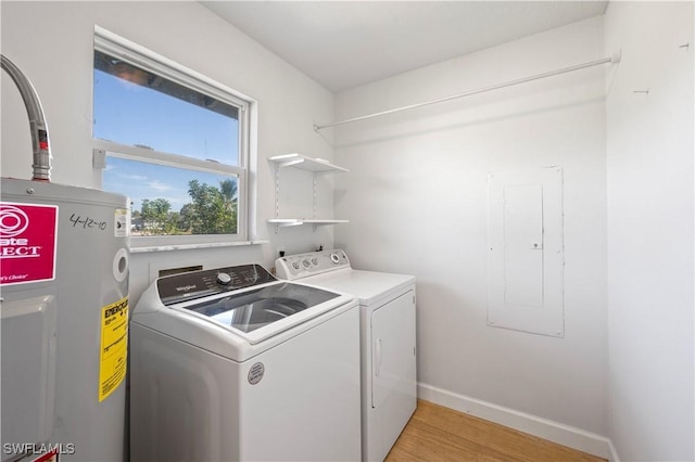 washroom featuring electric panel, electric water heater, light hardwood / wood-style flooring, and independent washer and dryer