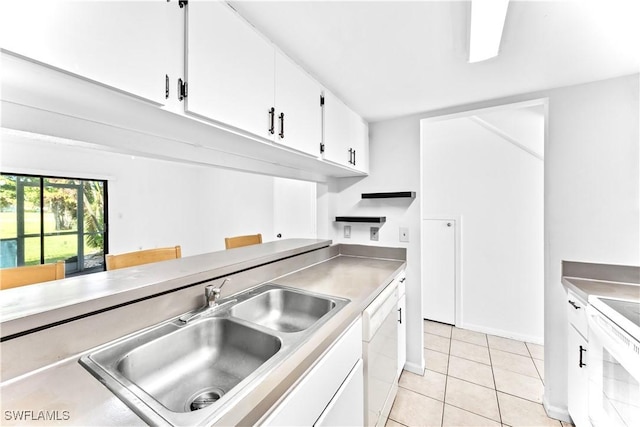 kitchen featuring white cabinetry, sink, stove, white dishwasher, and light tile patterned flooring