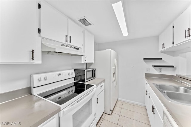 kitchen with sink, white cabinets, light tile patterned flooring, and white appliances