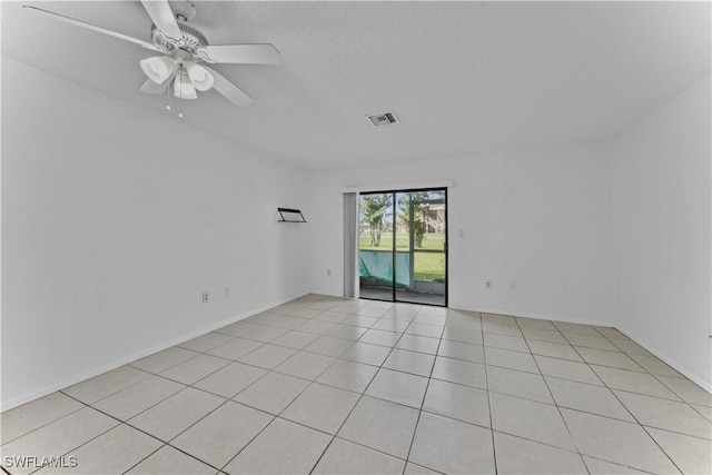 tiled spare room with ceiling fan