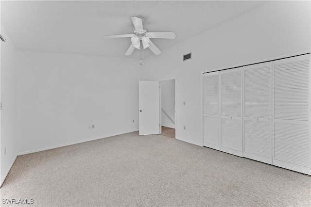 unfurnished bedroom with light carpet, a closet, and ceiling fan