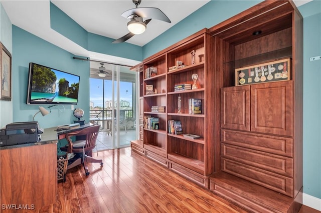 office area featuring hardwood / wood-style flooring, a wall of windows, and ceiling fan