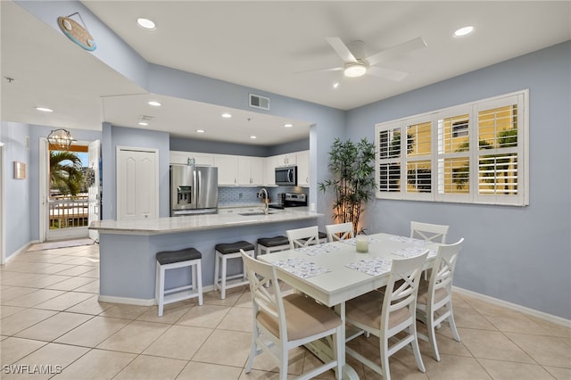 dining room with light tile patterned flooring, ceiling fan, and sink