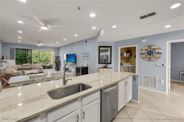 kitchen with washing machine and clothes dryer, white cabinetry, sink, dishwasher, and light stone counters