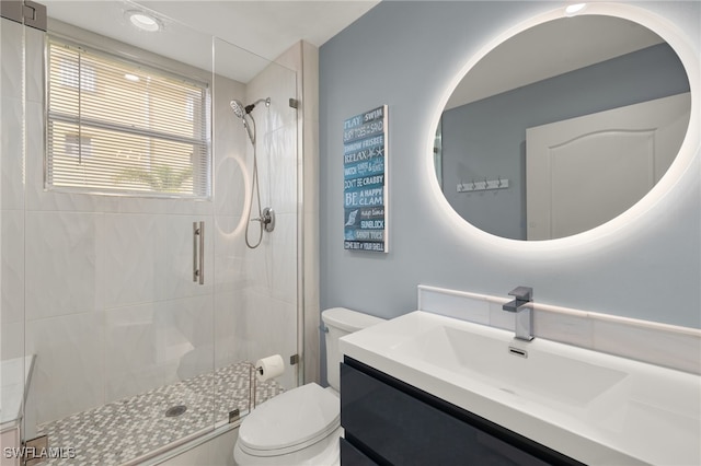 bathroom with a shower with door, vanity, and toilet