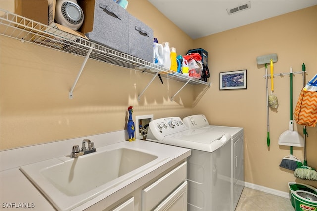 laundry area featuring washer and clothes dryer, light tile patterned flooring, and sink