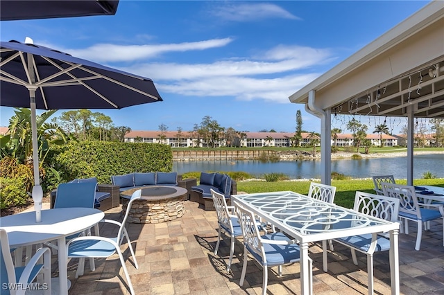 view of patio / terrace featuring a water view and an outdoor living space with a fire pit