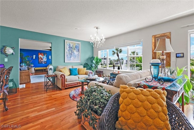 living room featuring a chandelier, a textured ceiling, and hardwood / wood-style flooring