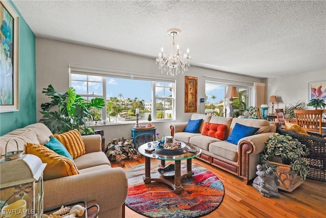 living room with a textured ceiling, light hardwood / wood-style flooring, and a chandelier