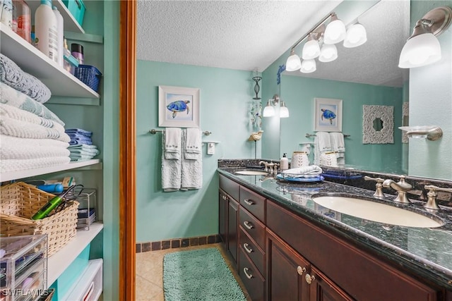 bathroom featuring tile patterned floors, vanity, and a textured ceiling