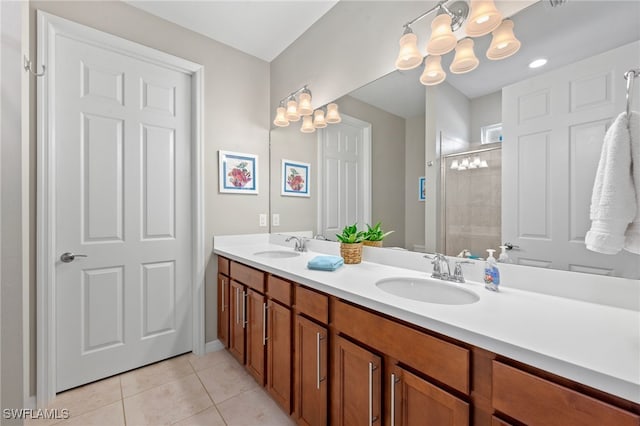 bathroom featuring tile patterned flooring, vanity, a shower with shower door, and an inviting chandelier