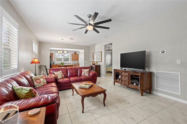 living room featuring light tile patterned floors and ceiling fan with notable chandelier