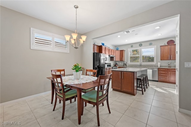 tiled dining area featuring a chandelier