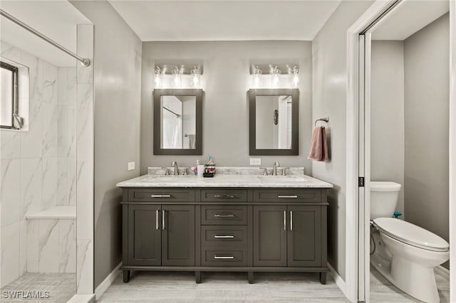 bathroom featuring tiled shower, vanity, and toilet