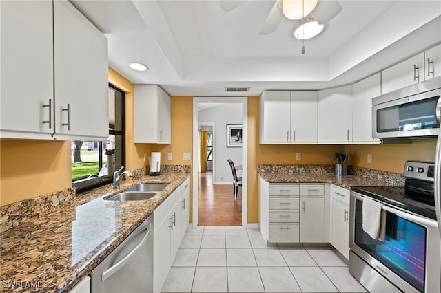 kitchen with white cabinetry, sink, dark stone counters, and appliances with stainless steel finishes