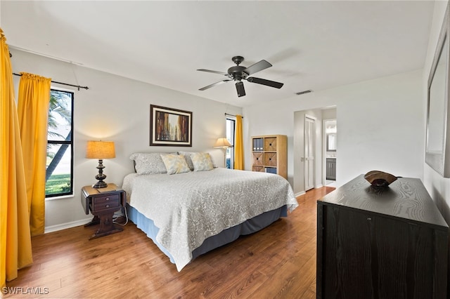 bedroom with hardwood / wood-style floors, ceiling fan, and ensuite bathroom