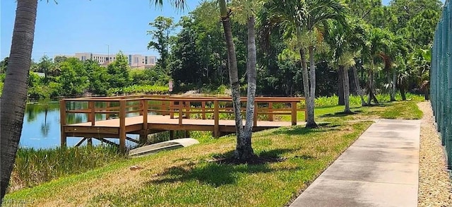 surrounding community featuring a water view and a lawn