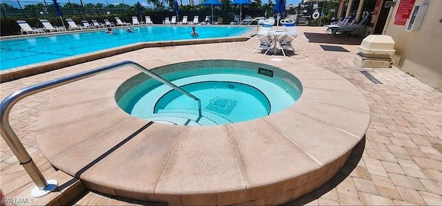 view of swimming pool with a patio area and a community hot tub