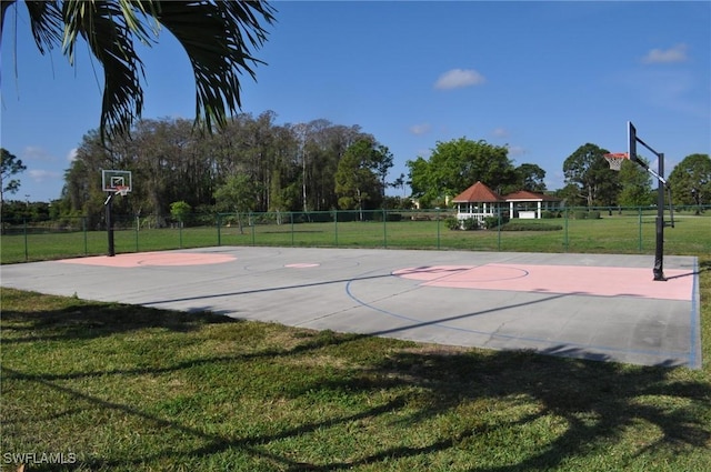 view of sport court featuring a lawn