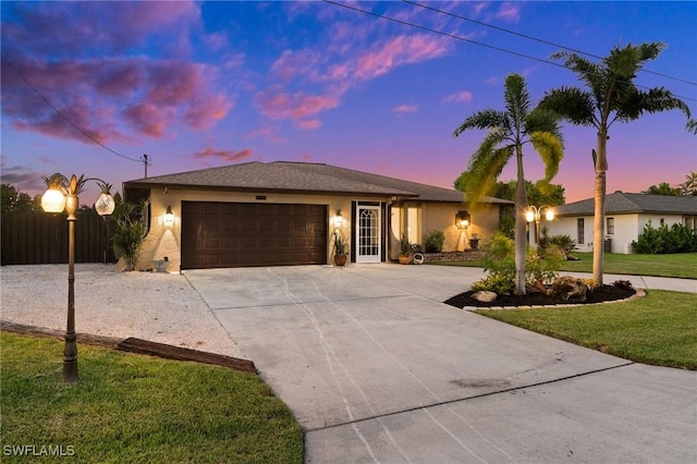 ranch-style home featuring a yard and a garage