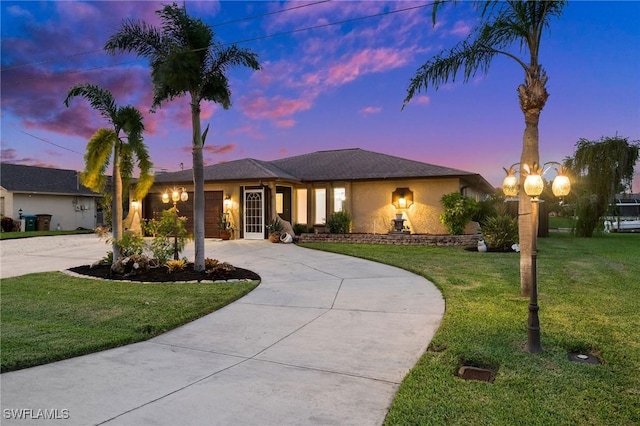 view of front of home with a yard and a garage