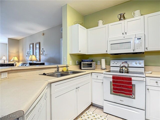 kitchen with white cabinetry, sink, kitchen peninsula, white appliances, and light tile patterned floors