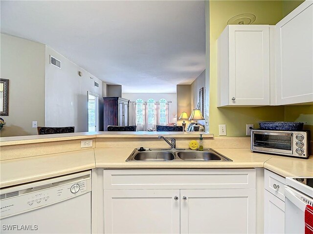 kitchen with white cabinets, dishwasher, kitchen peninsula, and sink