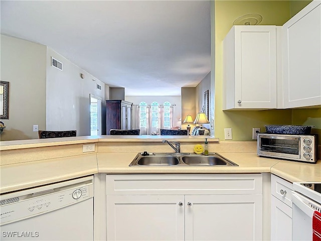 kitchen featuring white cabinetry, sink, white appliances, and kitchen peninsula