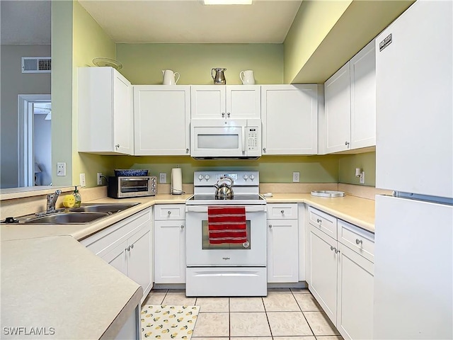 kitchen featuring white cabinets, light tile patterned flooring, white appliances, and sink