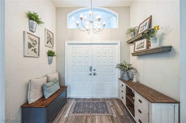 foyer entrance featuring dark hardwood / wood-style flooring and an inviting chandelier