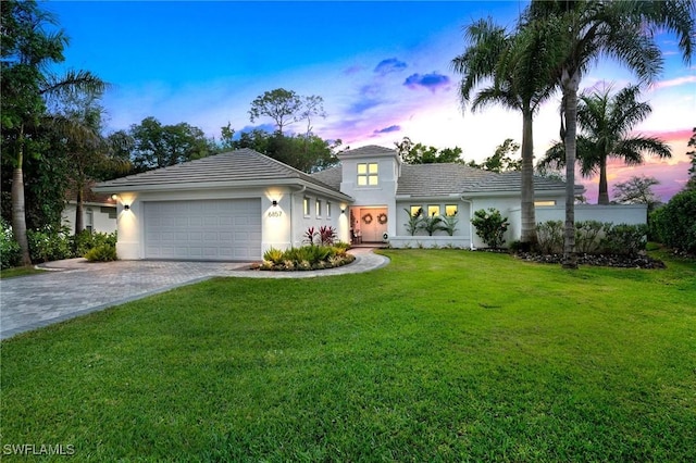 view of front of home with a yard and a garage