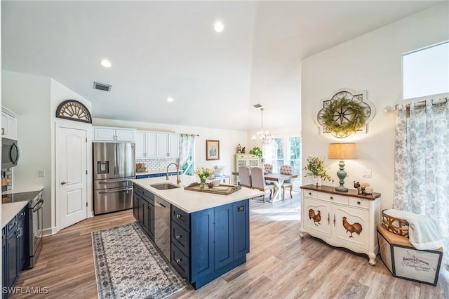 kitchen featuring tasteful backsplash, stainless steel appliances, sink, decorative light fixtures, and white cabinetry