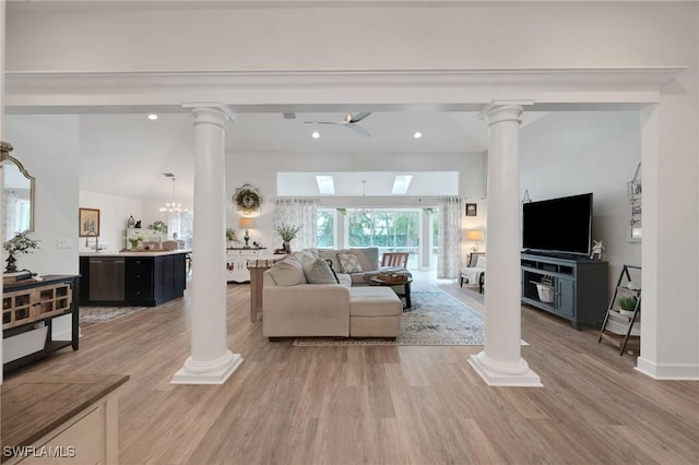 living room featuring ceiling fan with notable chandelier and light hardwood / wood-style floors