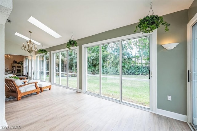 unfurnished sunroom with a notable chandelier and vaulted ceiling with skylight