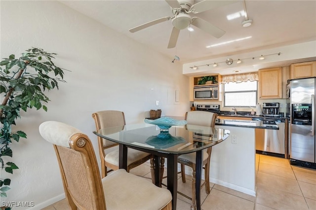 tiled dining space with ceiling fan and sink