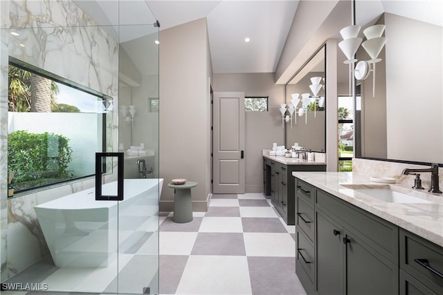 full bath with a stall shower, lofted ceiling, tile patterned floors, a sink, and two vanities