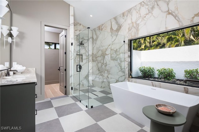 full bathroom featuring a marble finish shower, recessed lighting, a soaking tub, vanity, and tile patterned floors