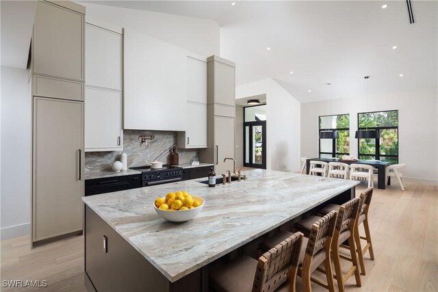 kitchen featuring electric range, a sink, white cabinets, backsplash, and modern cabinets