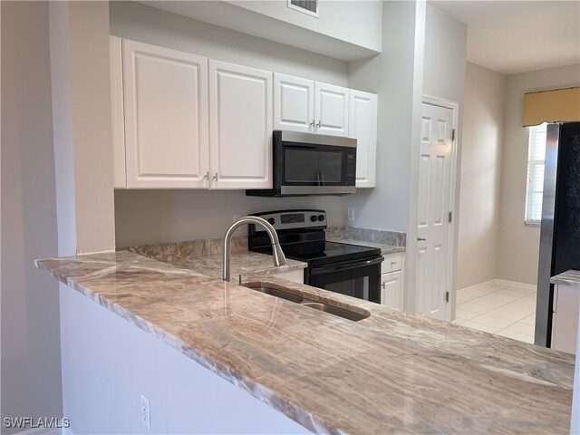 kitchen featuring white cabinetry, sink, light tile patterned floors, and stainless steel appliances