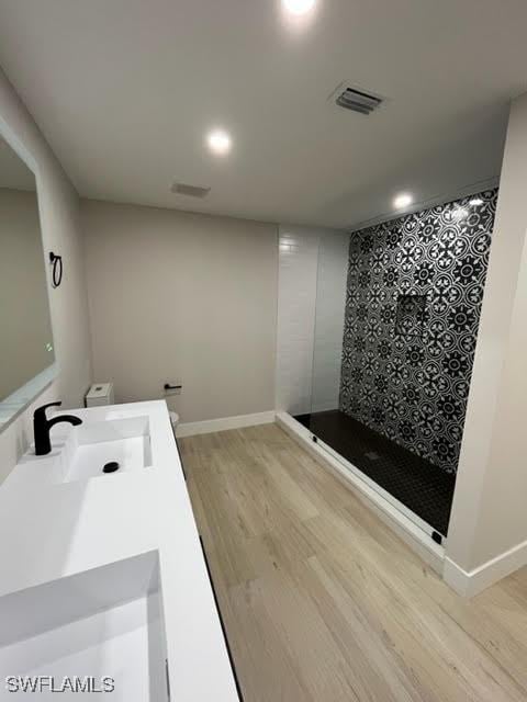 bathroom featuring vanity, wood-type flooring, and walk in shower