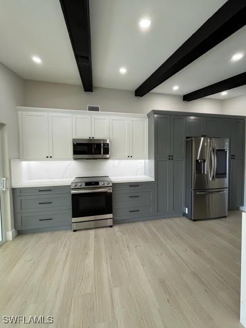 kitchen with gray cabinets, white cabinetry, beamed ceiling, and appliances with stainless steel finishes