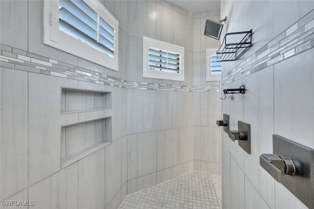 bathroom featuring plenty of natural light and tiled shower