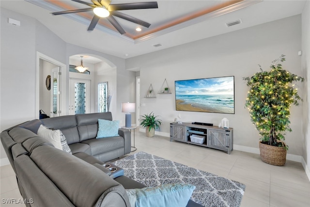 living room featuring ceiling fan, crown molding, and a tray ceiling