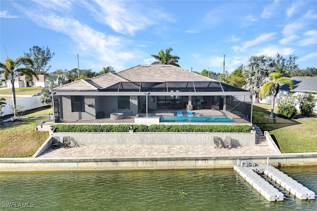 back of property with a water view and glass enclosure