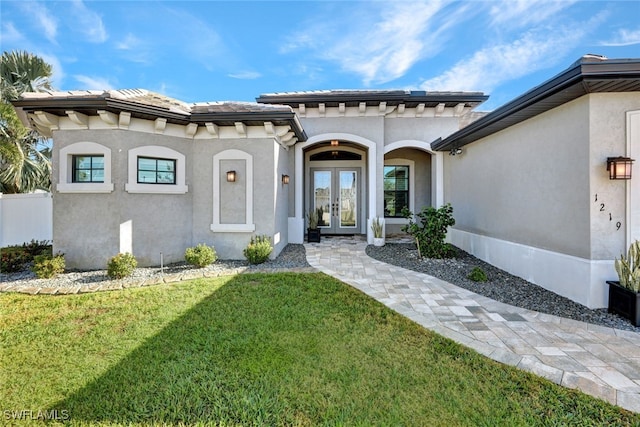 doorway to property featuring a yard and french doors