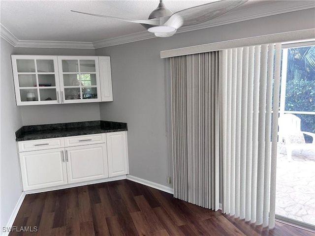 interior space with white cabinetry, ceiling fan, dark wood-type flooring, and crown molding