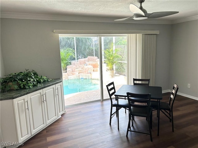 dining area featuring a textured ceiling, dark wood-type flooring, ceiling fan, and crown molding