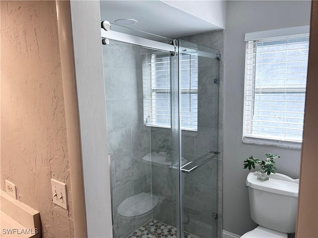 bathroom with toilet and a shower with shower door