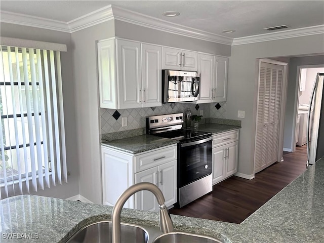 kitchen with sink, stainless steel appliances, backsplash, dark stone countertops, and white cabinets